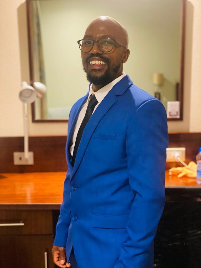 Hendrick Swarts, Director of Operations at Girls In STEAM, smiling in a blue suit